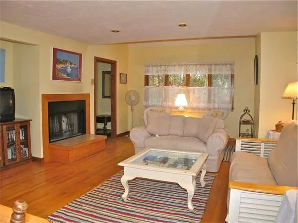 a living room with a fireplace furniture and a large window
