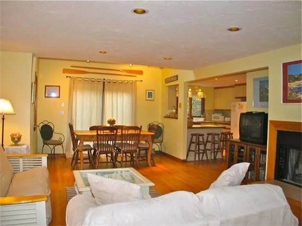 a living room with furniture flat screen tv and chairs