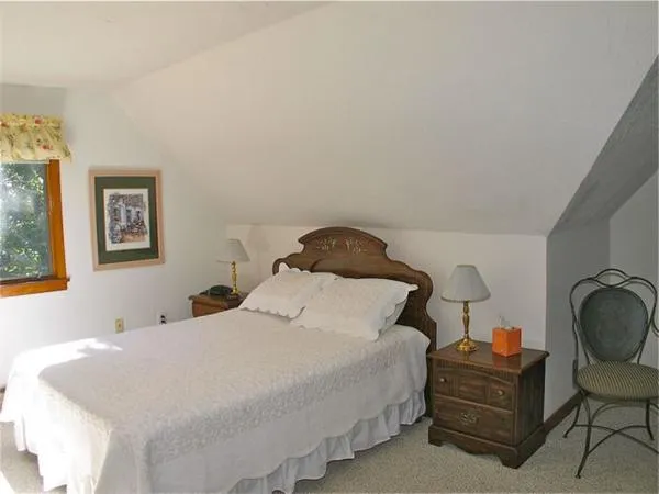 a bedroom with a bed and painting on the wall