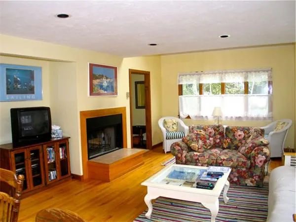 a living room with furniture a flat screen tv and a fireplace