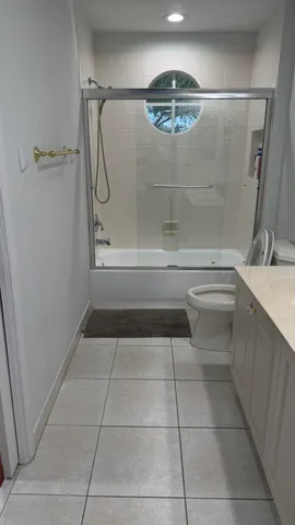 a bathroom with a glass shower door and a sink