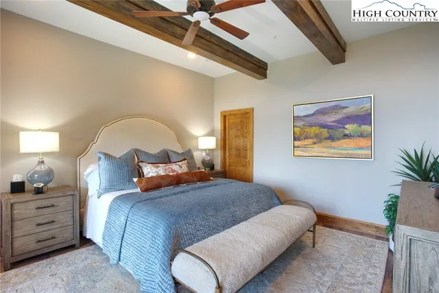 a bedroom with bed and paintings on the wall