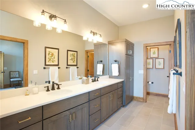 a bathroom with a double vanity sink mirror and shower