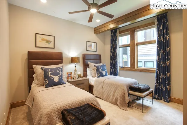 a bedroom with two beds and a large window