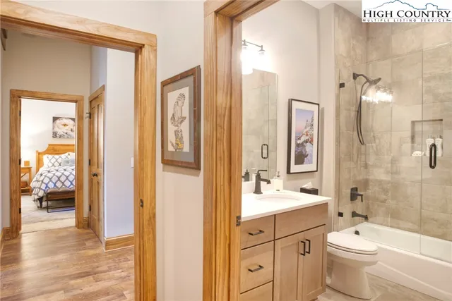 a bathroom with a double vanity sink toilet mirror and bathtub