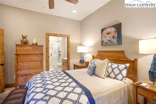 a bedroom with a bed and a lamp on dresser