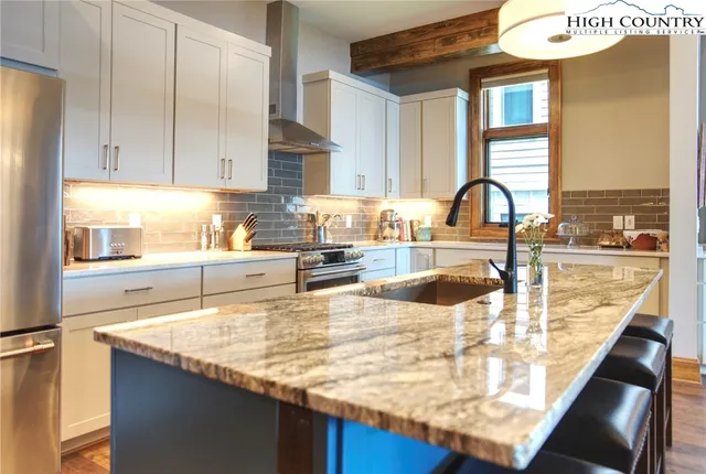 a kitchen with granite countertop a sink and a stove top oven