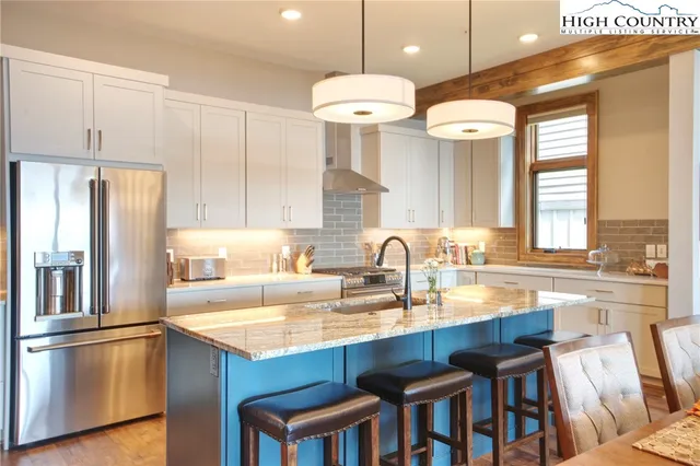 a kitchen with granite countertop a sink cabinets and stainless steel appliances