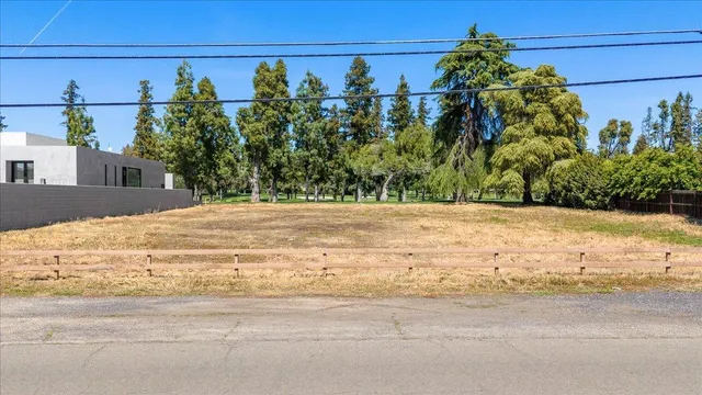 a view of dirt field with trees in the background