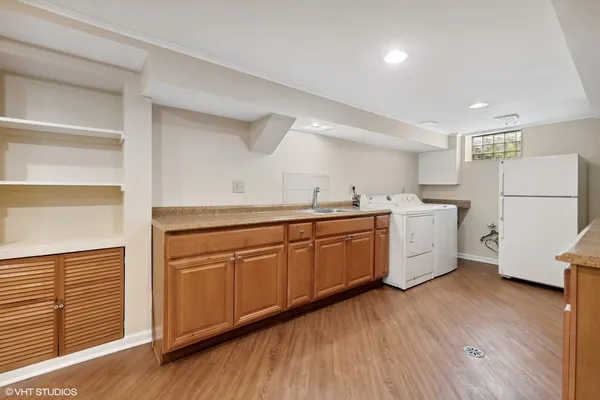 a kitchen with a sink a refrigerator and wooden floor