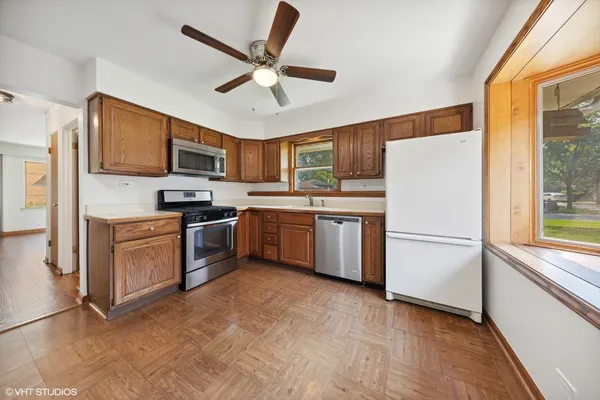 a kitchen with cabinets stainless steel appliances and a window