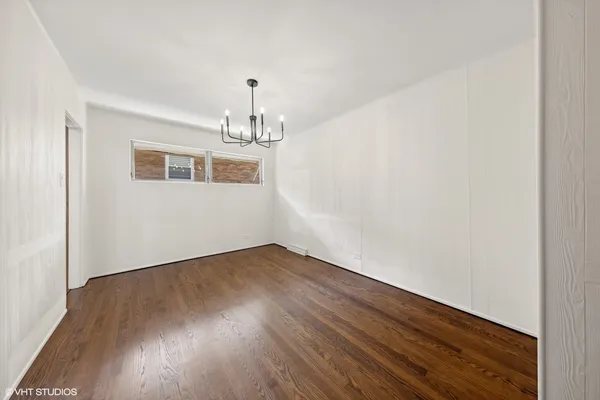 a view of a room with wooden floor and chandelier