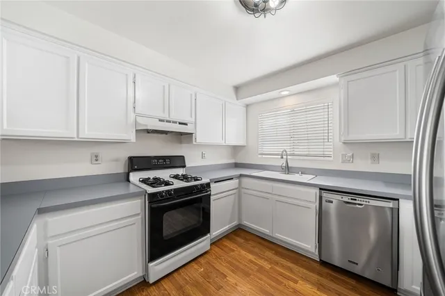 a kitchen with white cabinets stainless steel appliances and sink
