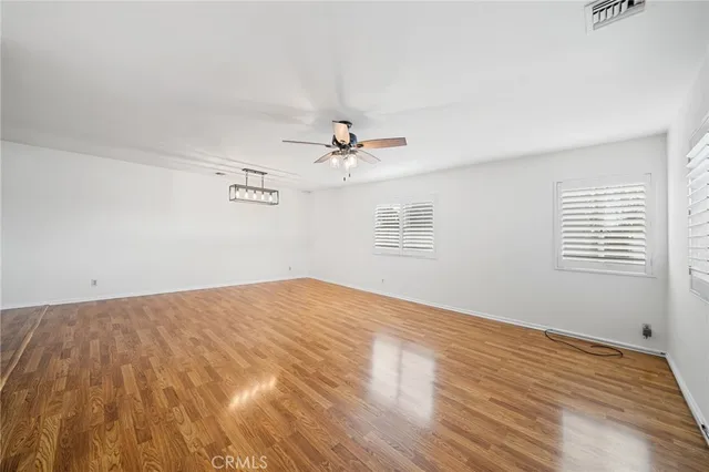 a view of a room with wooden floor and ceiling fan