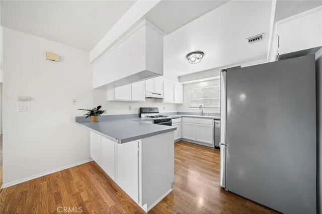 a kitchen with a sink cabinets and wooden floor
