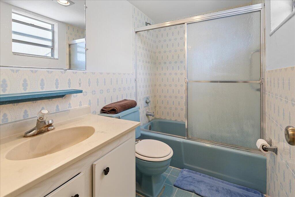 1124 Northwest 13th Street, Unit 120A Boca Raton, FL 33486 - Photo 11 of 22 a bathroom with a sink a toilet and shower