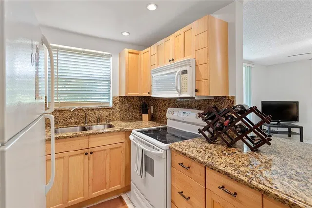 a kitchen with a sink stove top oven and cabinets