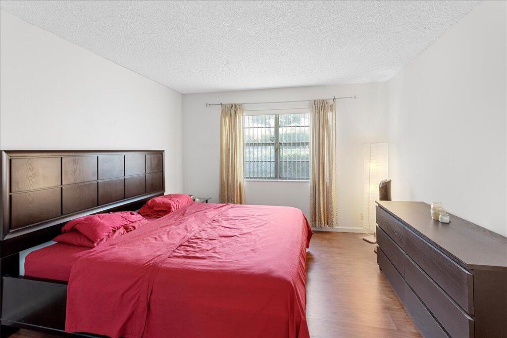 1124 Northwest 13th Street, Unit 120A Boca Raton, FL 33486 - Photo 8 of 22 a bedroom with a bed and a window