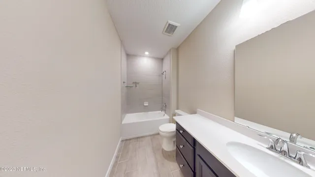 a bathroom with a sink a toilet a mirror and shower