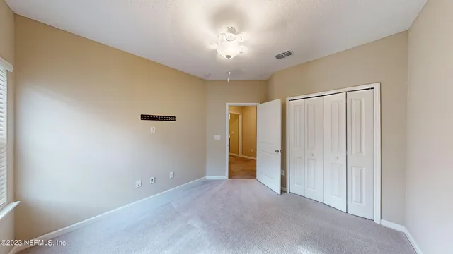 an empty room with windows and closet