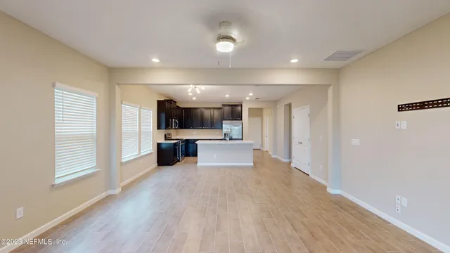 a kitchen with kitchen island granite countertop wooden cabinets a sink and a stove
