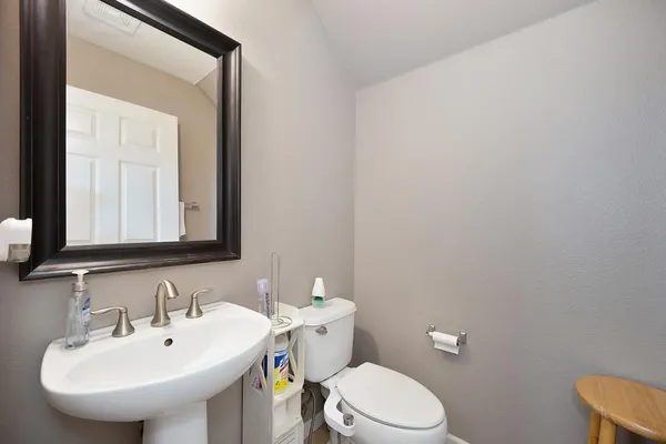 a bathroom with a toilet a sink and mirror