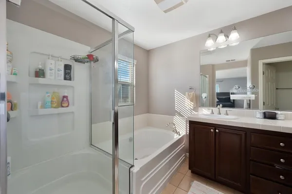 a bathroom with a tub sink and mirror
