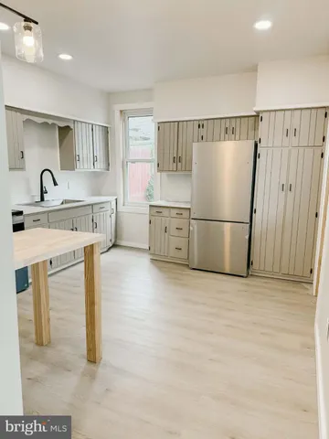 a kitchen with a refrigerator a sink and cabinets