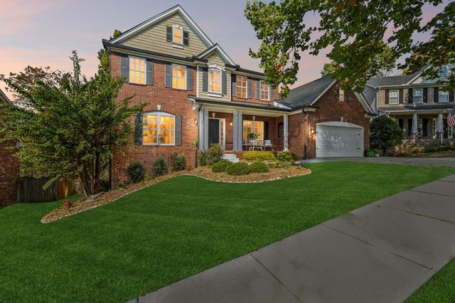 a front view of a house with a yard and trees