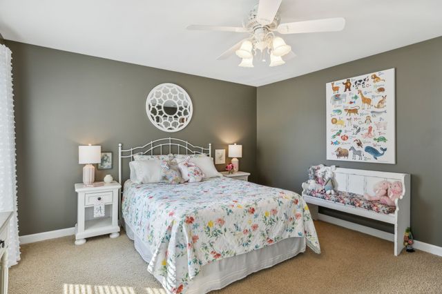 a bedroom with a bed and a lamp on dresser