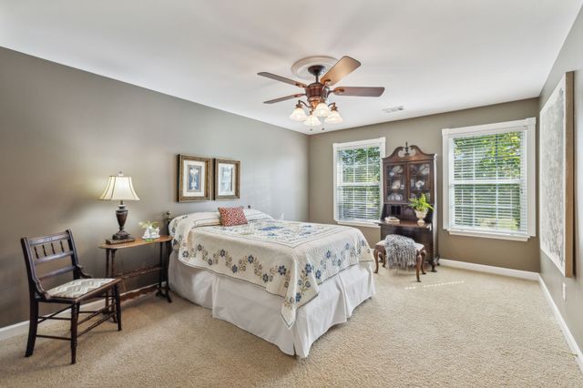 a spacious bedroom with a bed a chandelier and a couch