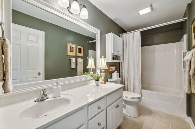 a bathroom with a granite countertop sink a toilet and shower