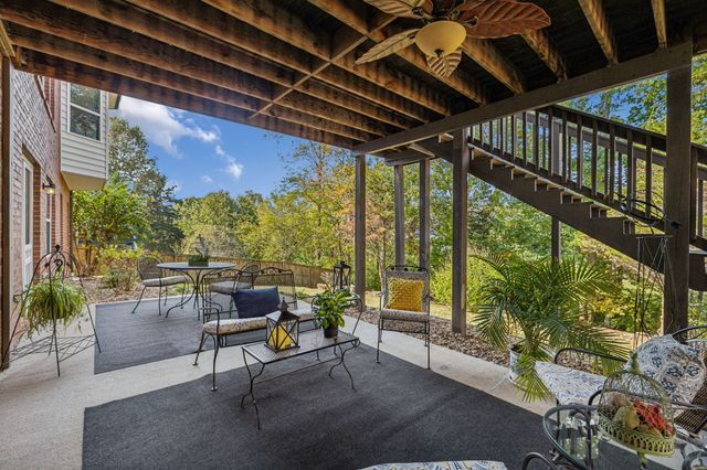 a roof deck with table and chairs and potted plants