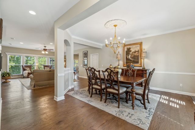 a dining room with furniture a chandelier and wooden floor