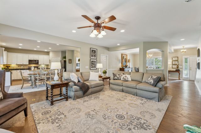 a living room with furniture and view of kitchen