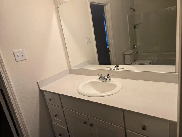 a white toilet sitting next to a bath tub