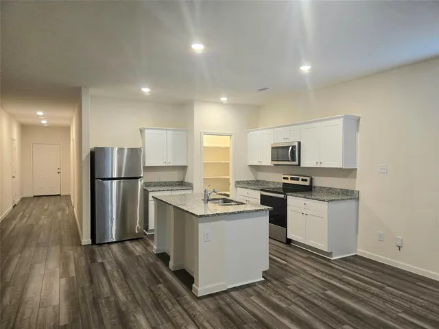 a kitchen with stainless steel appliances granite countertop a stove a sink and a refrigerator