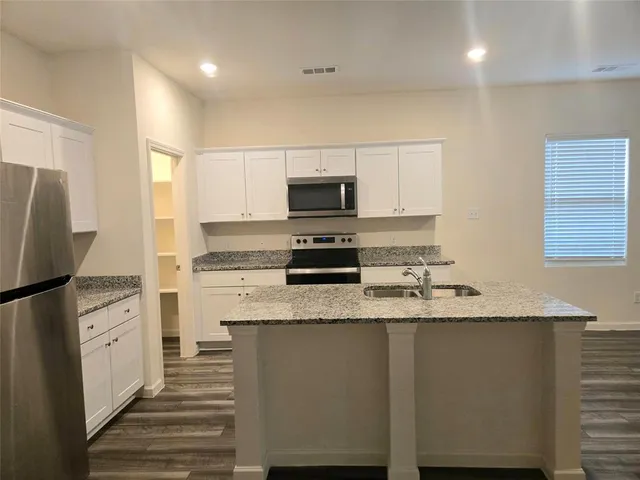 a view of a kitchen with wooden floor and a sink
