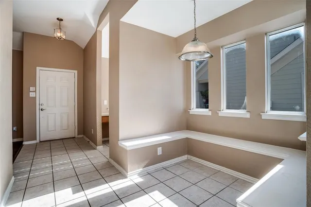 a view of an empty room with window and cabinet