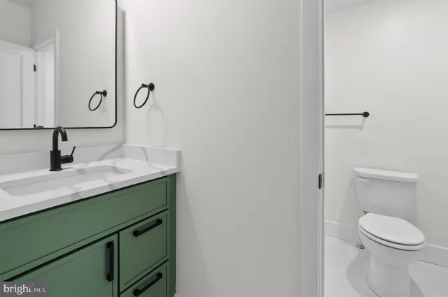 a bathroom with a toilet sink and mirror