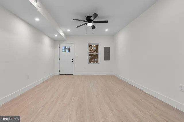 an empty room with fan and windows