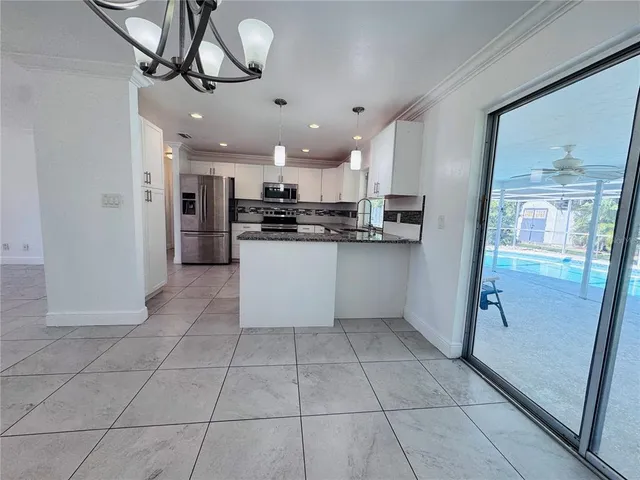 a kitchen with stainless steel appliances granite countertop a refrigerator and microwave