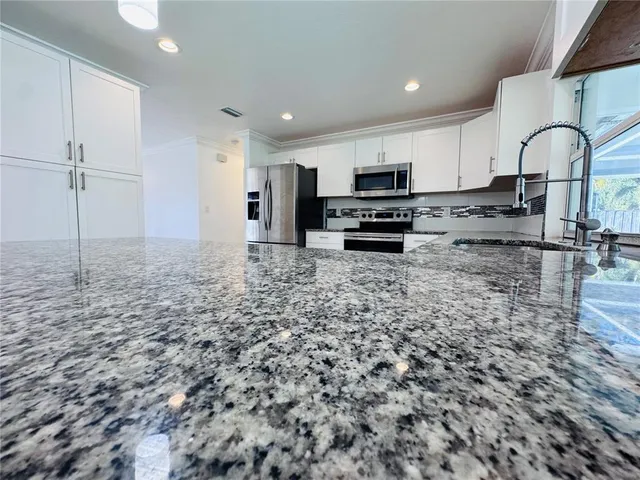 a kitchen with kitchen island a sink stainless steel appliances and cabinets