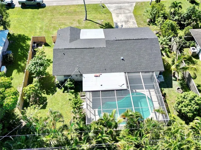 an aerial view of a house with a yard and large trees