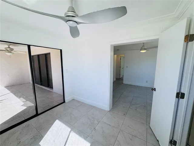 a view of an empty room and a ceiling fan