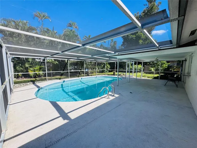 a view of a backyard with table and chairs under an umbrella
