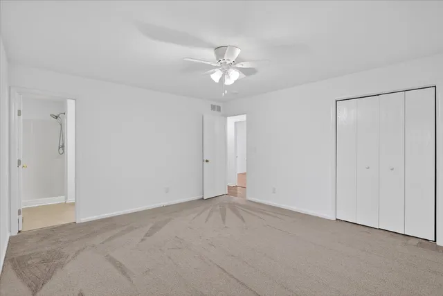 a view of an empty room with a ceiling fan