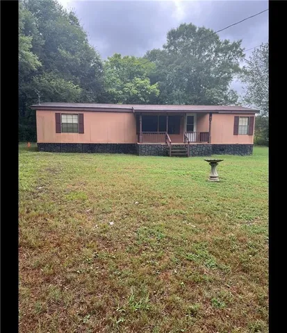 a view of a backyard with plants and large trees