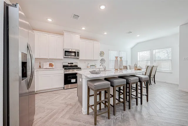 a kitchen with stainless steel appliances granite countertop a stove a sink and a microwave