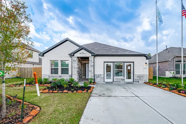 a front view of a house with a yard and potted plants